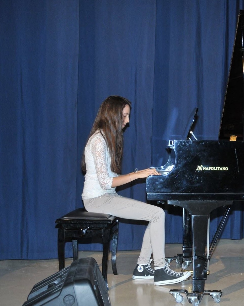 Giovane allieva dell'Istituto Corriero suona il pianoforte durante un saggio