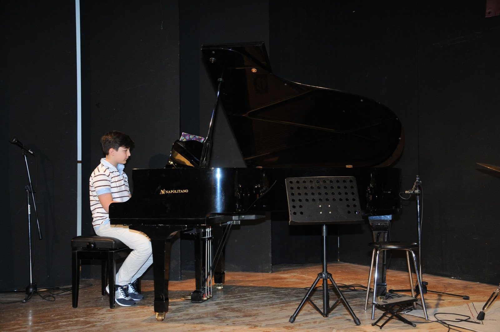 Giovane allievo dell'Istituto Corriero suona il pianoforte durante un saggio